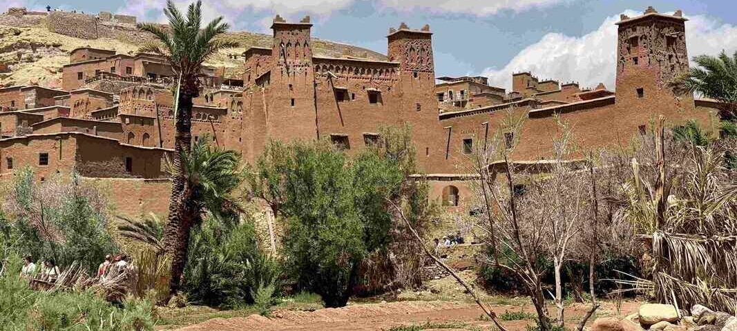 Traditional Moroccan kasbah surrounded by palm trees in southern Morocco.