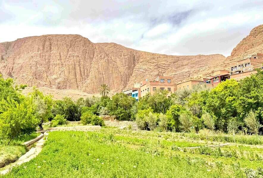 Green oasis and traditional village surrounded by dramatic cliffs in Todra Valley, Morocco.